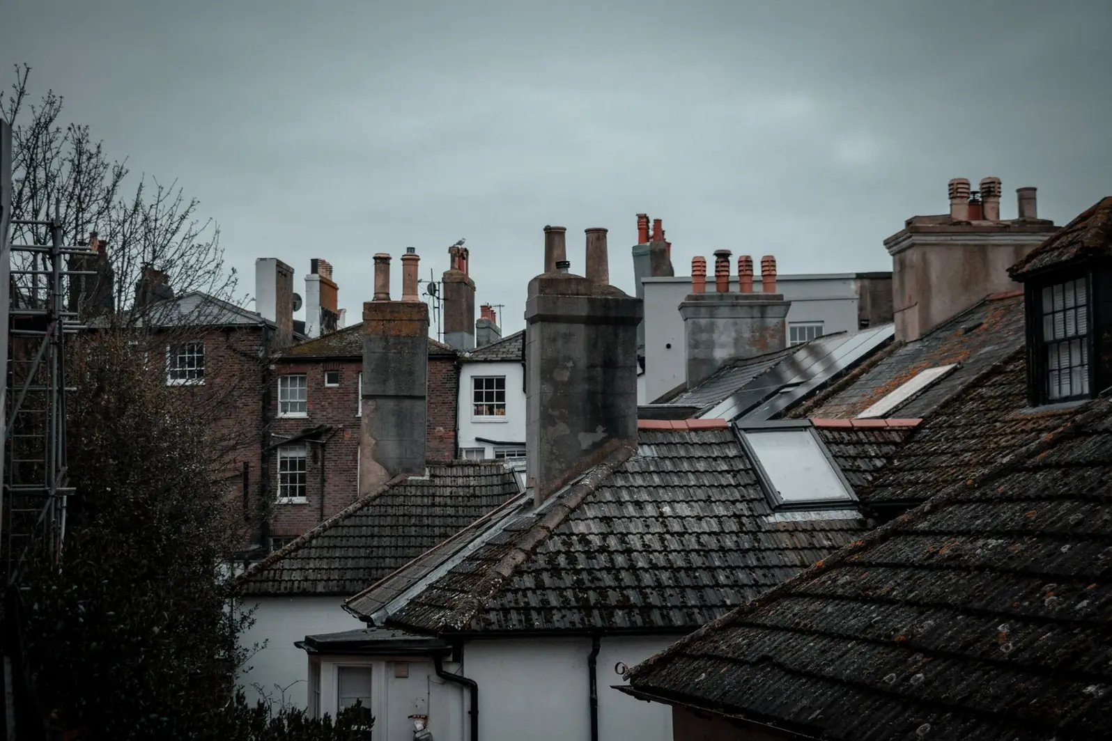 Toits d'un quartier ancien avec fenêtres de toit et souches de cheminée