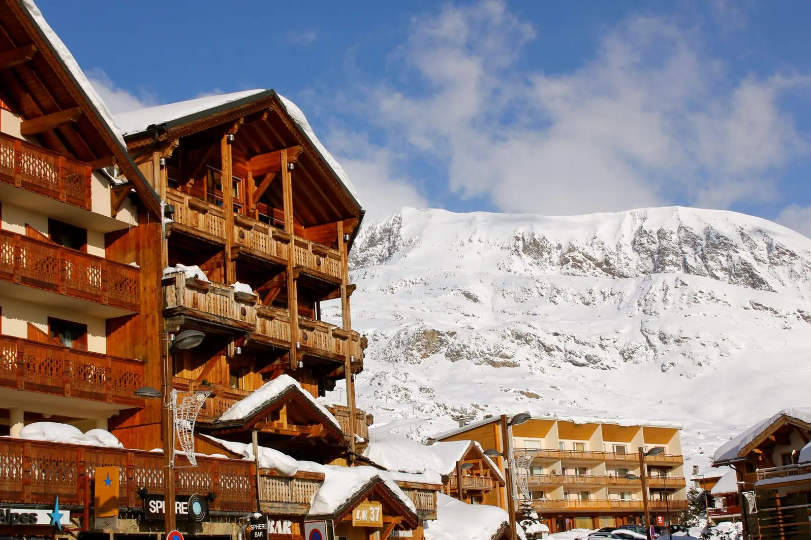 Chalets à grands débords de toit devant un versant enneigé