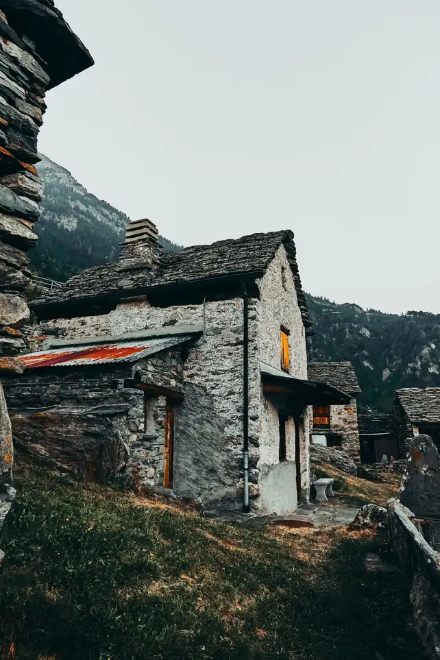 Bâtisse de pierre couverte en lauzes, posée en bord de pente