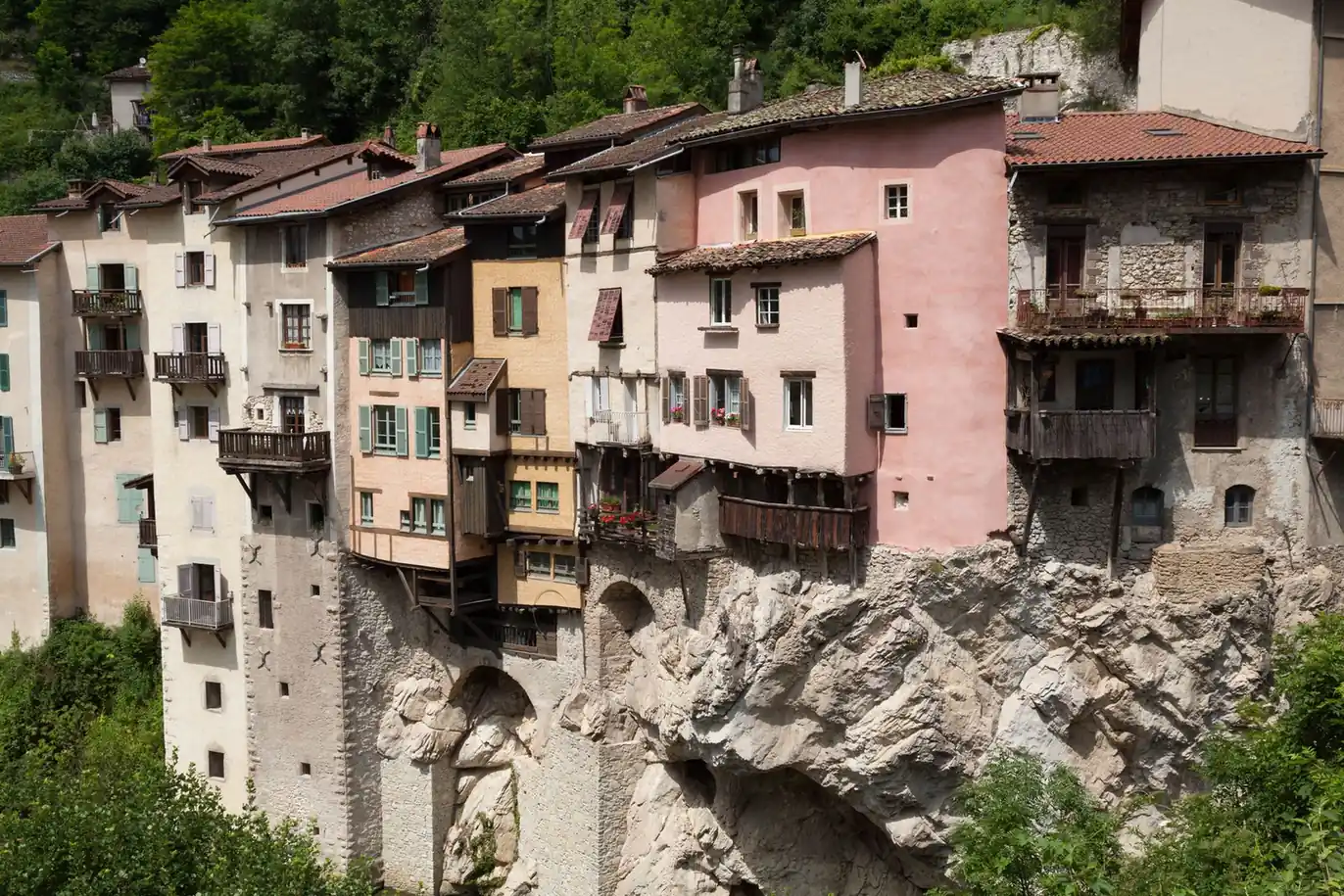 Maisons accrochées au rocher, toitures serrées au-dessus du vide